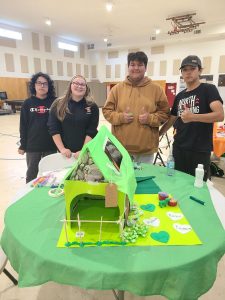Youth participants in the green group showcasing their completed dog house.