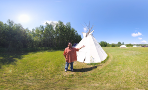 man standing in front of a tepee introducing the Pays Plat VR Pow Wow 
