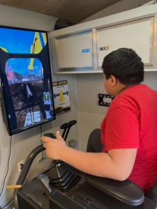 Youth using a CAT Heavy Equipment simulator 